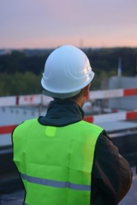 Construction worker in hard hat looks out over site