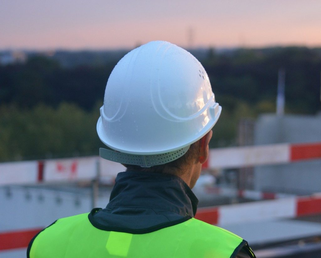 Construction worker in hard hat looks out over site