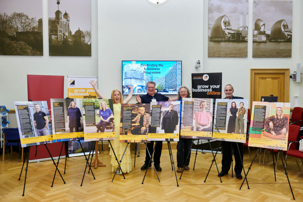 Tony Goldstein and others stand behind boards telling the story of various SMEs helped by the free E-business programme.