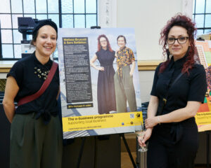 founders Melissa Bruscoli and Sara Battiston from The London Leather Workshop in Greenwich standing with the display board explaining their story and how the programme has helped them.