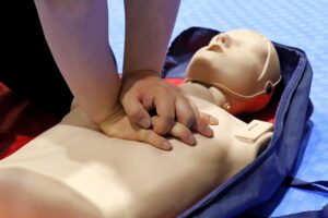 Image of young person's hands pushing on the chest of a CRP dummy